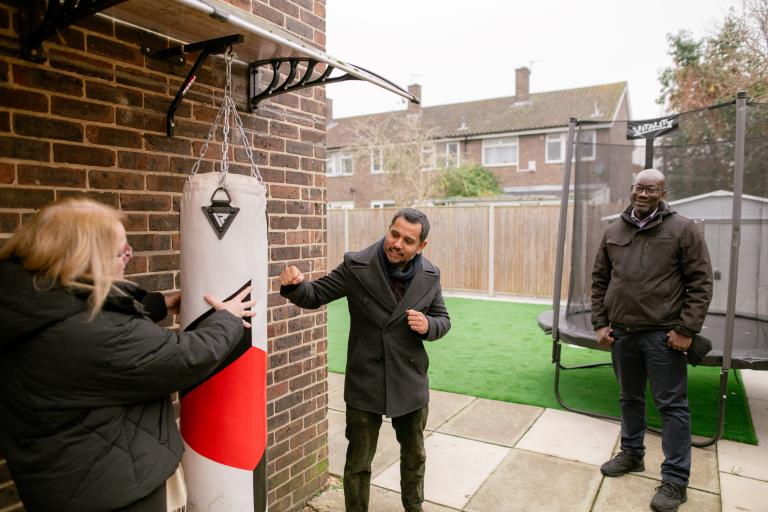 Photo showing Cabinet Member for Planning, Estate Renewal and Development Cllr Majid Rahman trying the punching bag at the children's care home.