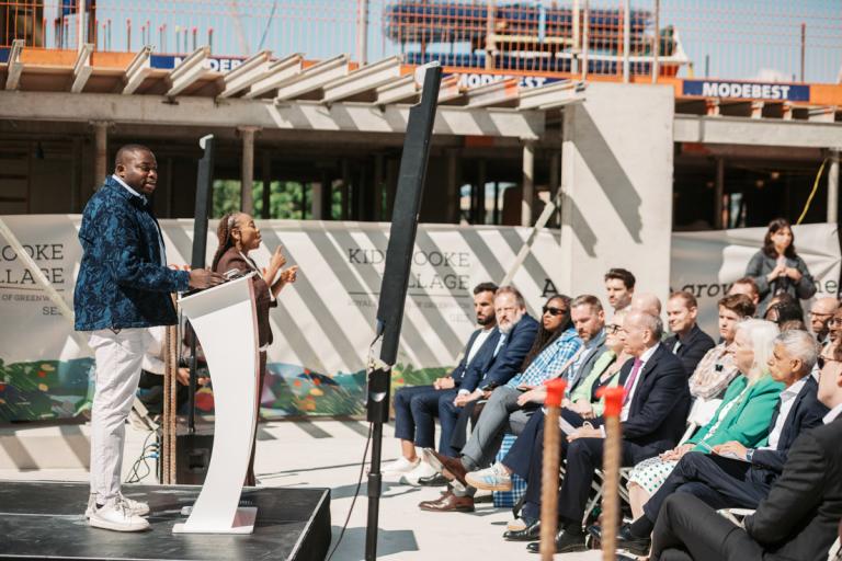 Photo of Cllr Anthony Okereke standing at a podium in front of an audience.