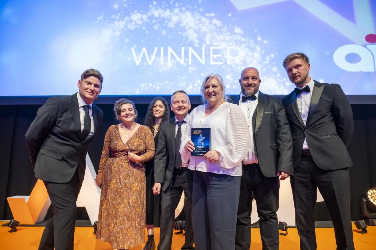 Group of staff from the Repairs & Investment and Digital, Operations and Access Teams, collect their award.