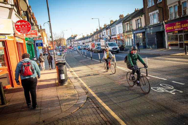 A picture showing a street in Greenwich which shows cyclists using the cycle lane