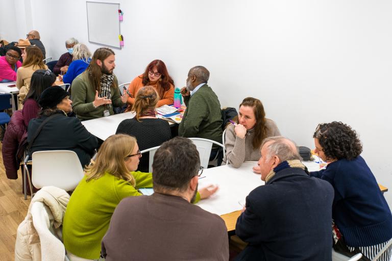 Residents gathered about a table having a discussion