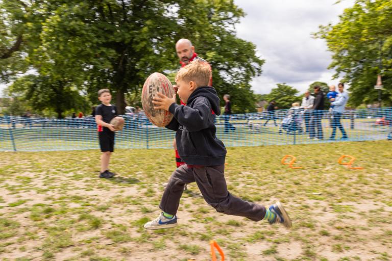 Child playing rugby at Plumstead Make Merry