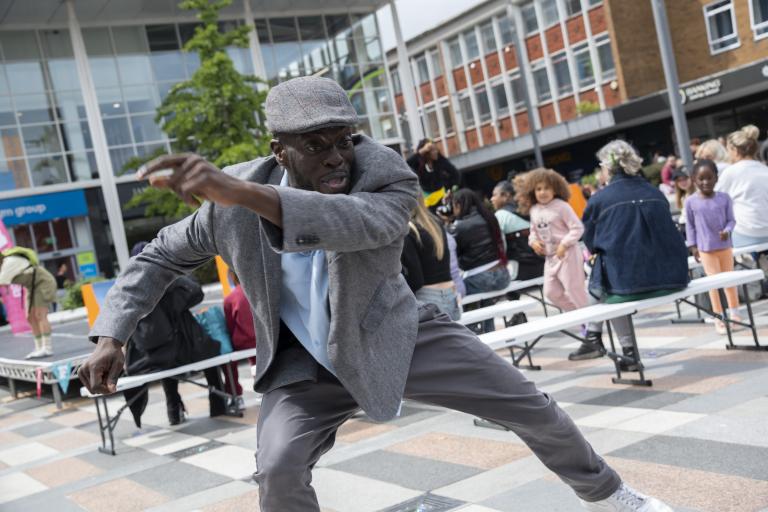 A man dancing in a public square outdoors.