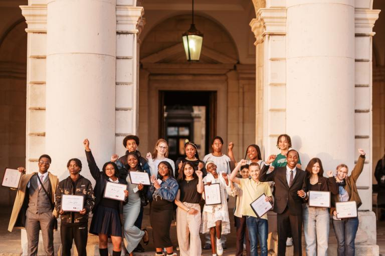 A diverse group of students in celebrating their achievements within Greenwich Young People's Council.