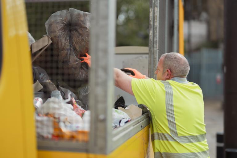 A man putting rubbish in a lorry