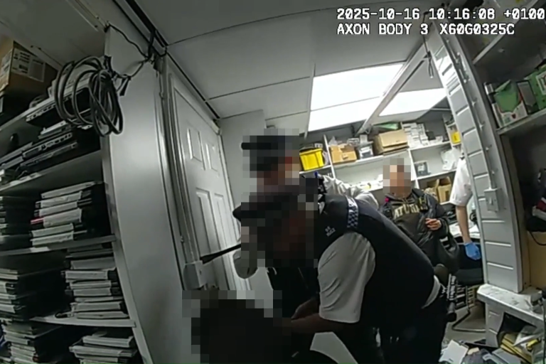 A screenshot of bodycam footage of 2 police officers opening a secret room