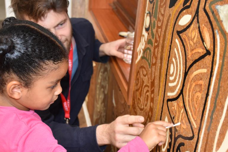 A Brooklands school pupil takes a close up look at the William Mitchell mural with restorer Frtizi Von Preussen
