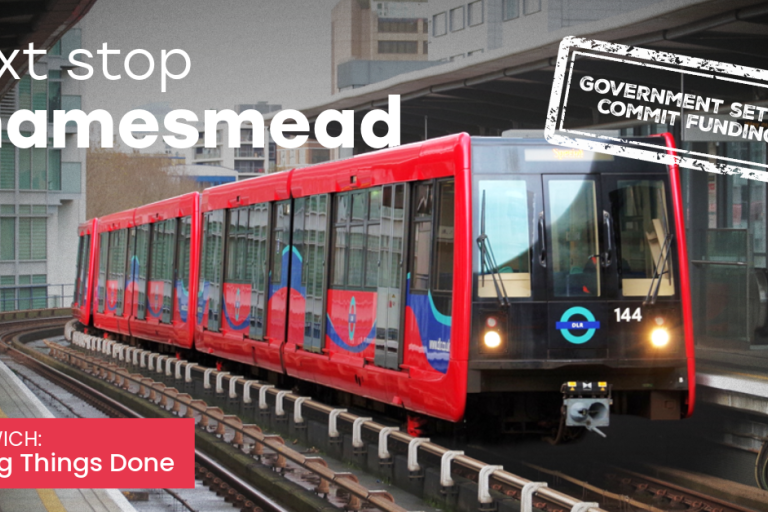 A DLR train at a platform with the caption "Next stop Thamesmead"