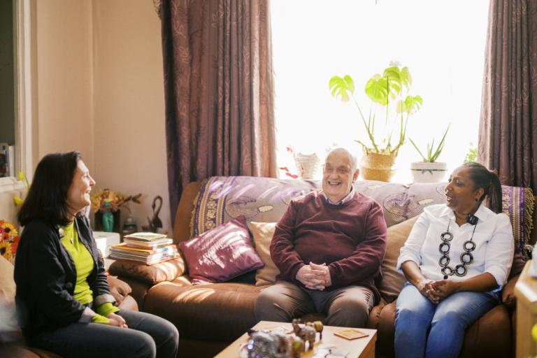 Councillor Mariam Lolavar chats with Sandra and Collin, participants in Shared Lives, in their living room