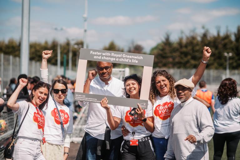 A group of people with their hands in the air wearing tshirts that say Could you? 