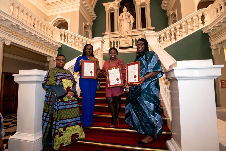 Civic Award winners from 2022, showcasing their certificates on the stairs at Woolwich Town Hall