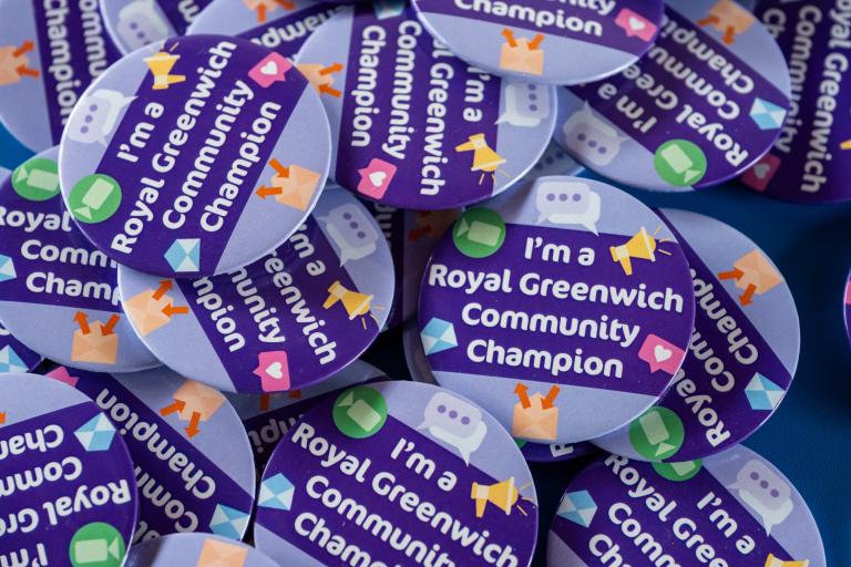 A pile of purple badges that I'm a Royal Greenwich Community Champion.