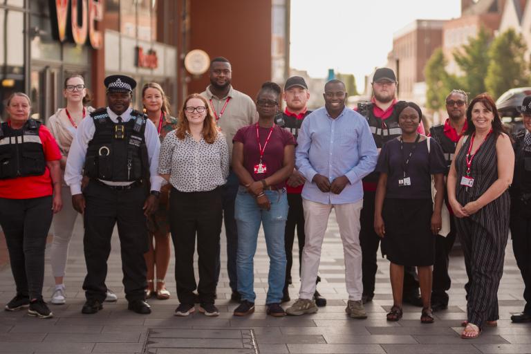 A group of council staff, Councillors and police officers stand for a group photo.