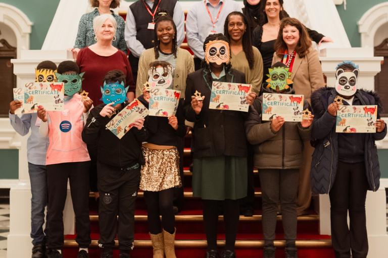 group of children holding certificates, councillors, members of Creating Ground, guest panel speakers and council staff.