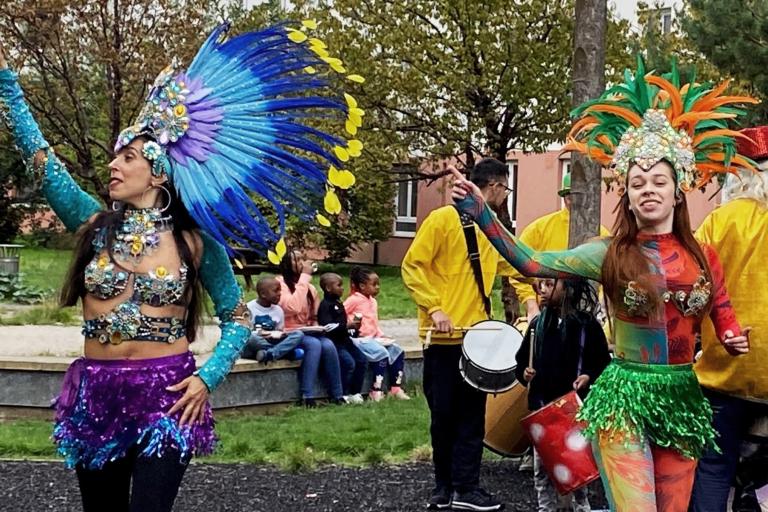 Two carnival dancers standing before a marching band.