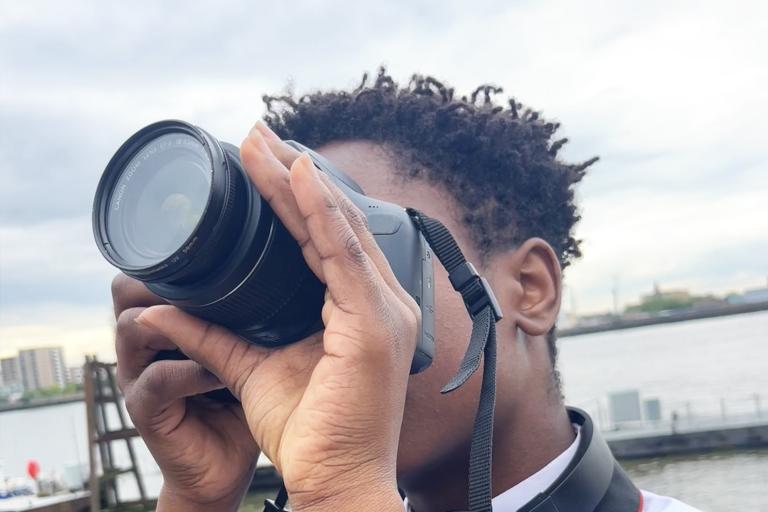 A young man taking a photo using a professional camera.