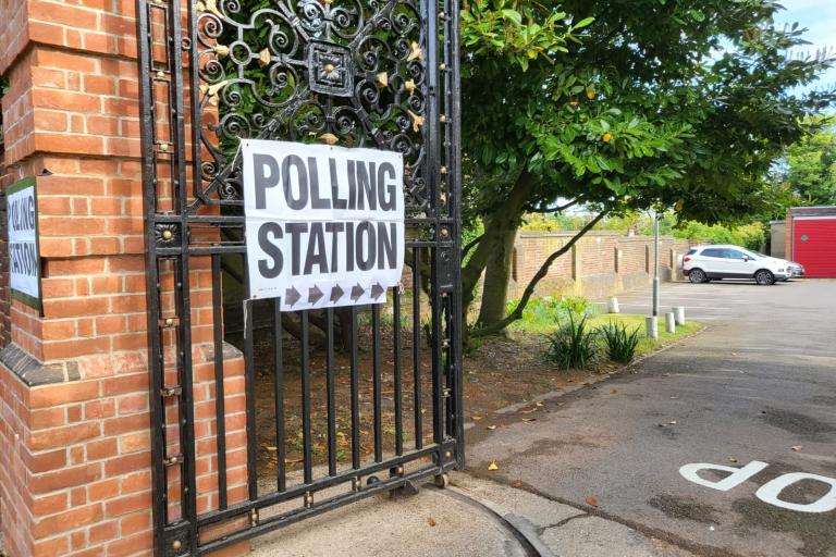 A sign on a gate that says 'polling station'
