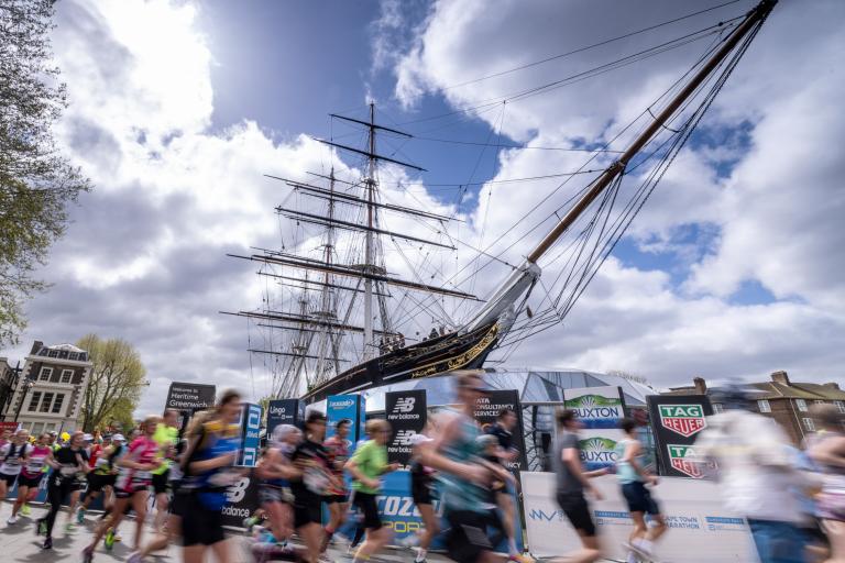 The Cutty Sark in the sun on marathon day, with runners blurred out in the foreground