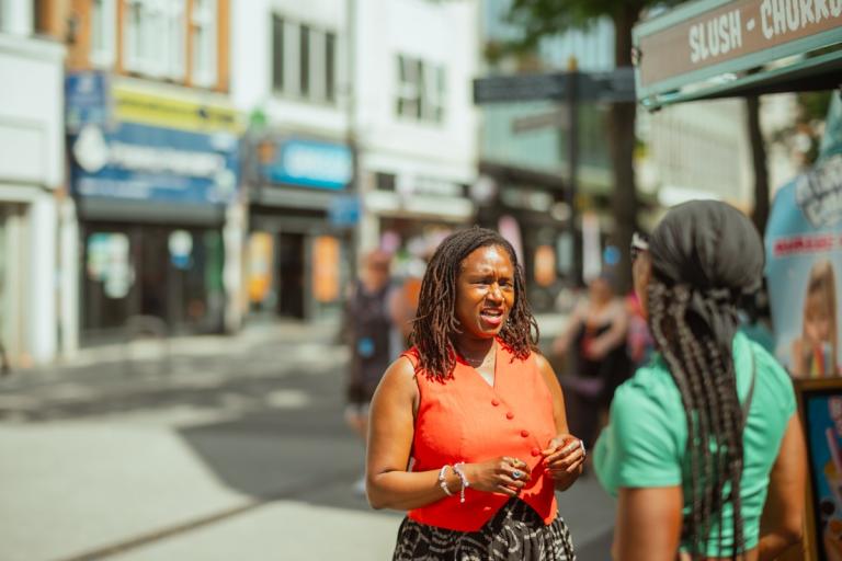 Kaia talks to a stall holder in Woolwich town centre.