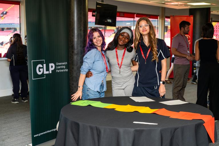 Three members of GYPC pose for the camera around one of the activities they've created for the children