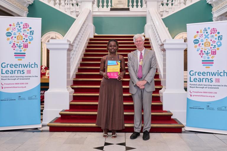 Amina holds up her certificate at the Town Hall with the Mayor, Cllr David Gardner