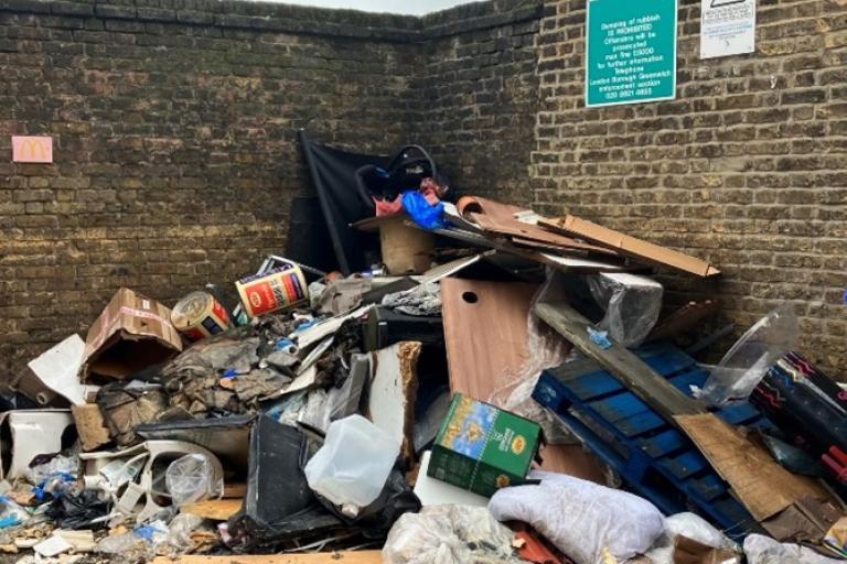 A pile of fly-tipped waste ruining a public place.