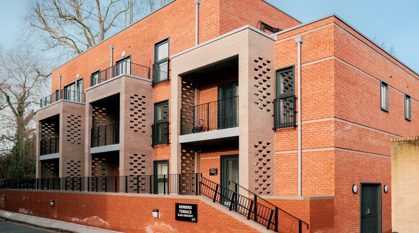 The new development of council apartments at Bliss Crescent, in a single three-storey block with a modern red brick design and balconies in brown brick.