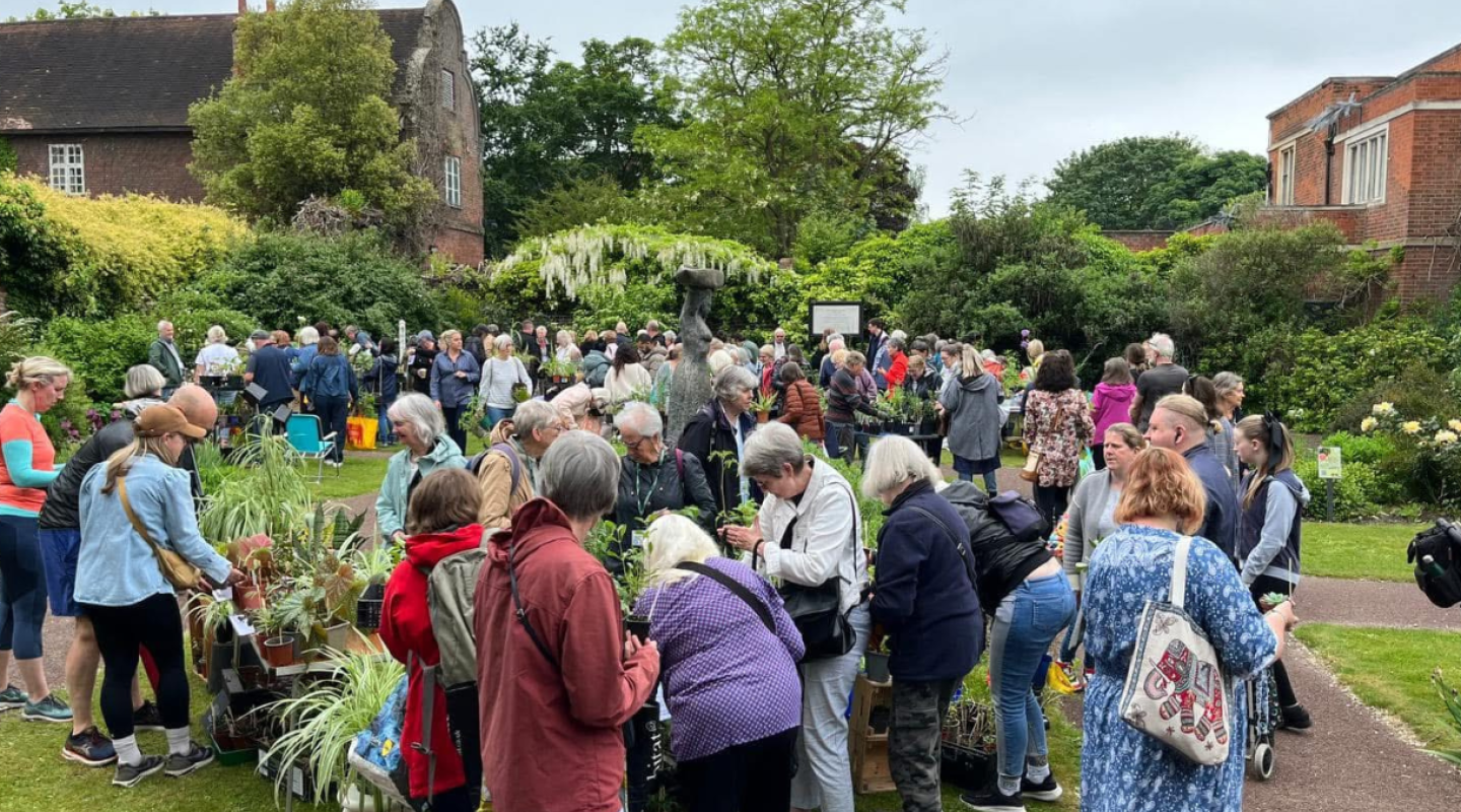 A group of people at a plant fair in the gardens at Charlton House
