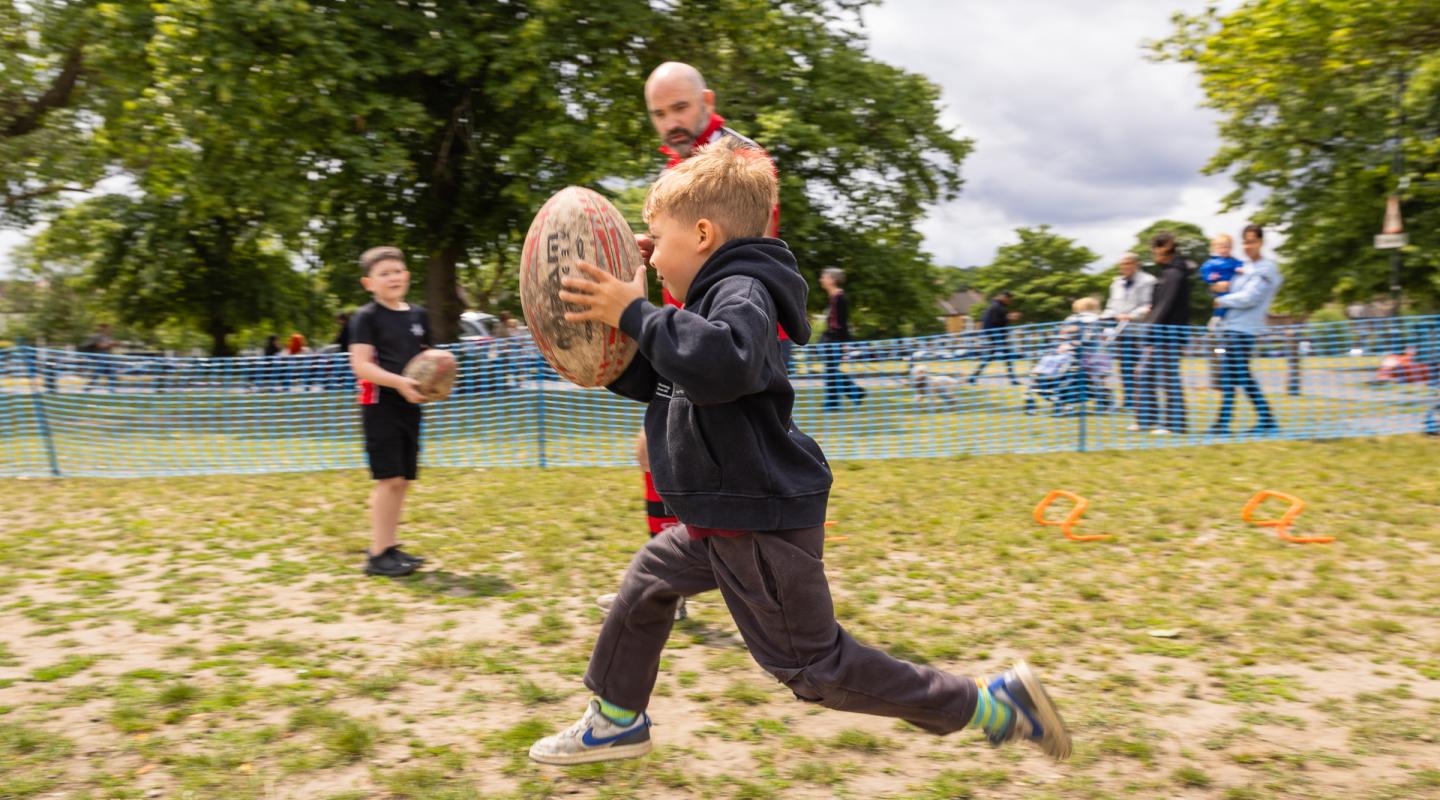 Child playing rugby at Plumstead Make Merry