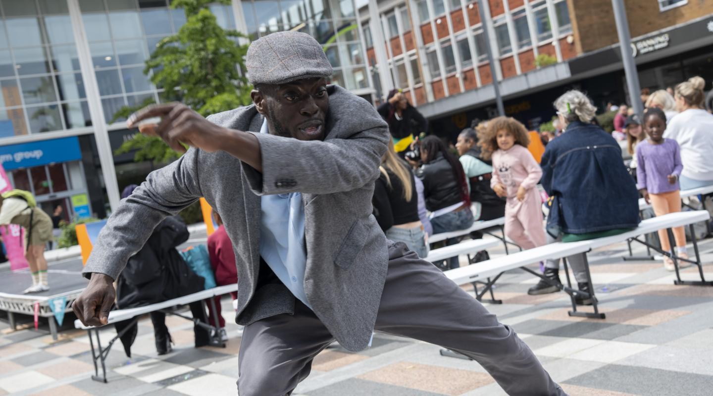 A man dancing in a public square outdoors.