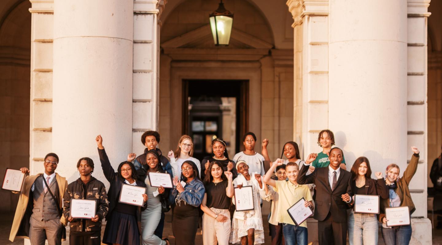 A diverse group of students in celebrating their achievements within Greenwich Young People's Council.