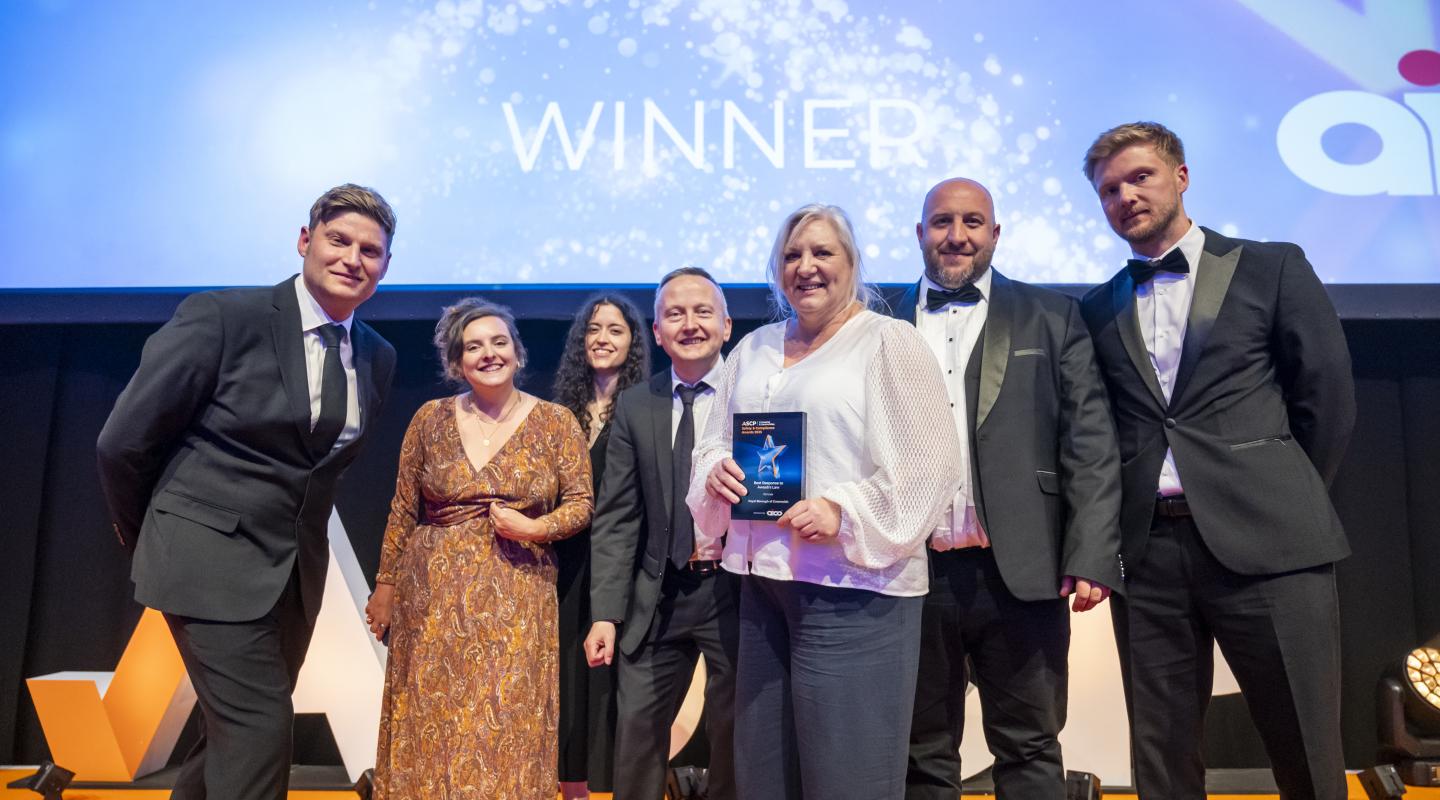 Group of staff from the Repairs & Investment and Digital, Operations and Access Teams, collect their award.