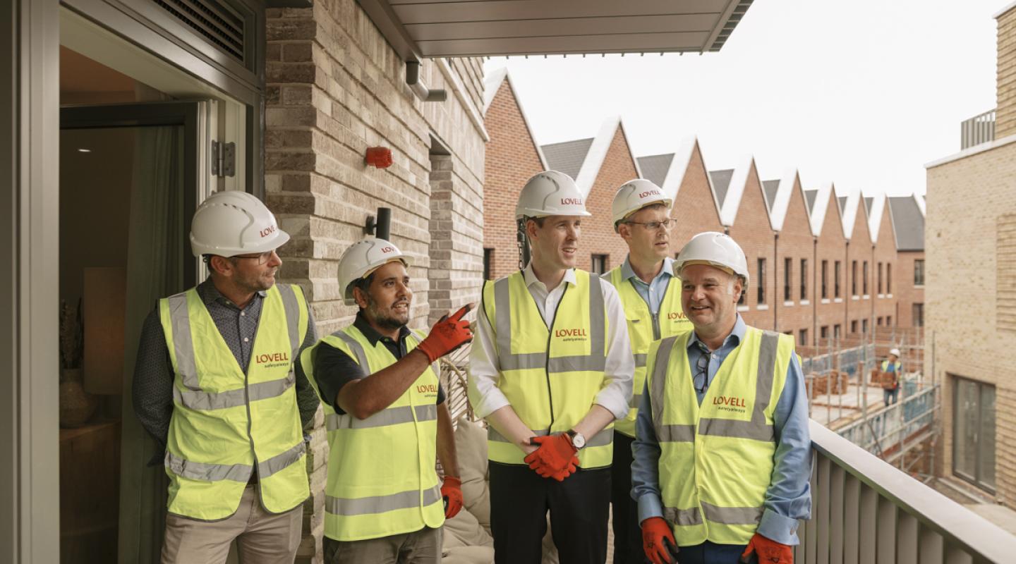 Councillor Majid Rahman with housing minister Matthew Pennycook (both centre of the image) at Woolwich Estates